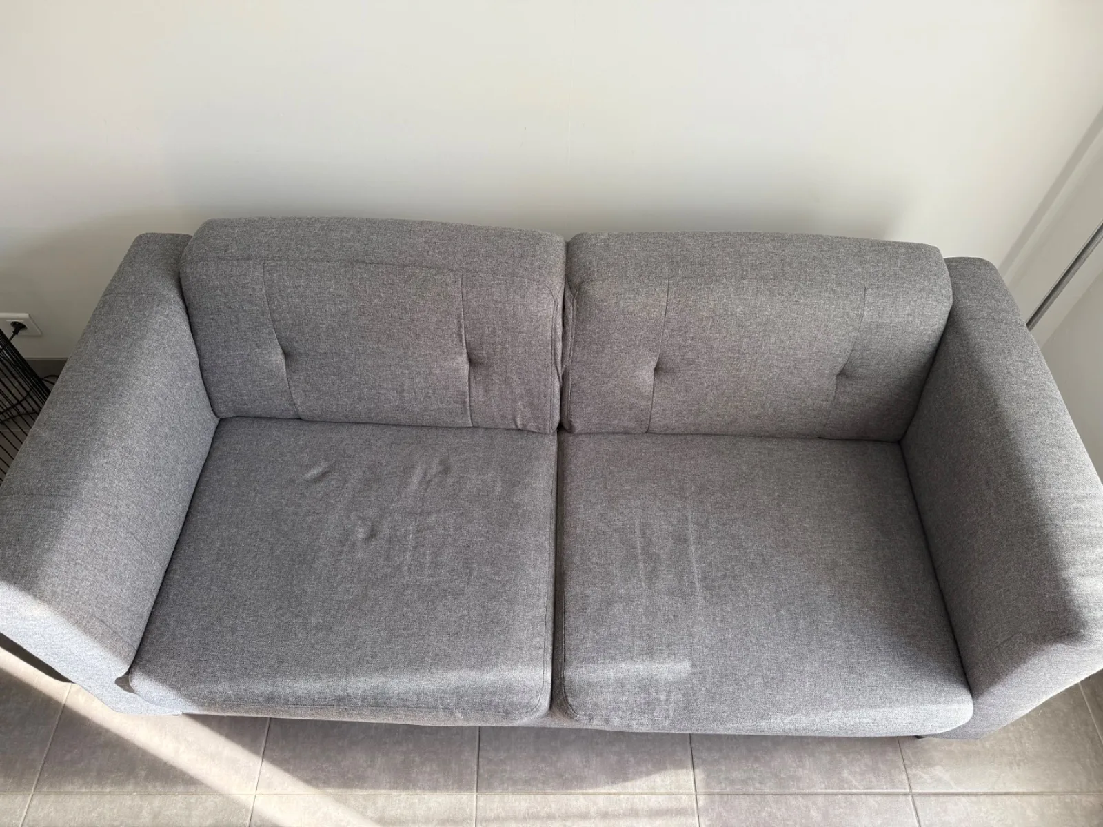 Canapé deux places en tissu gris nettoyé par Oventys dans une colocation à Grenoble